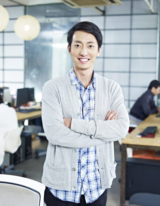 man smiling and standing with arms folded