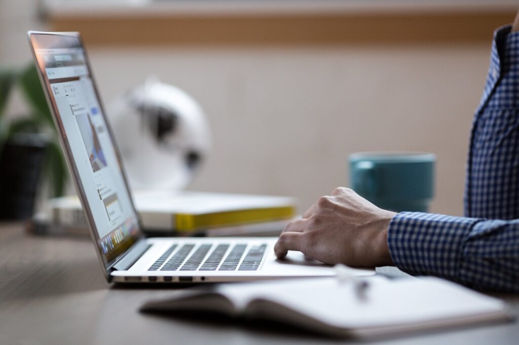 Person Typing On A Laptop, Shows Remote Work Or Digital Financial Services.