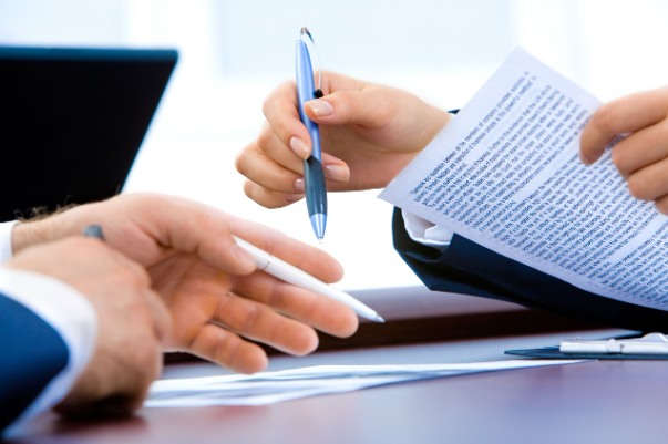 Business professionals reviewing financial documents during a review engagement meeting, representing limited assurance services and financial statement review procedures in Canada.